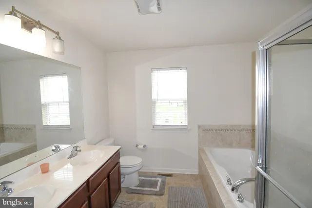 a bathroom with a tub sink toilet and a window