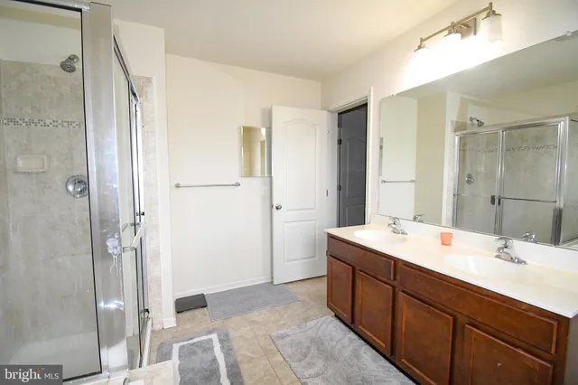 a spacious bathroom with a double vanity sink mirror and shower