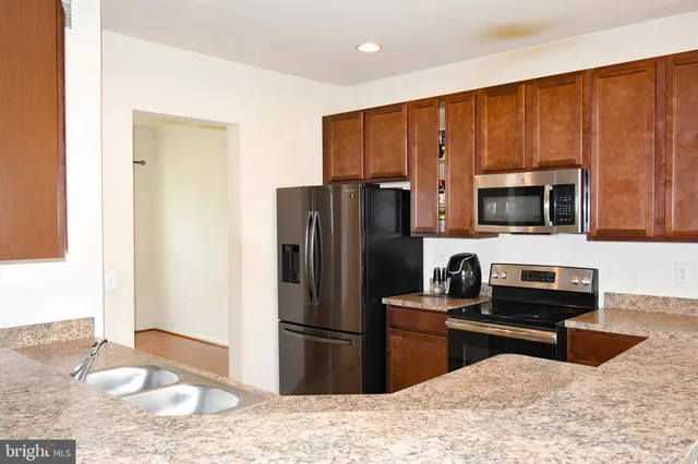 a kitchen with stainless steel appliances granite countertop a refrigerator stove and microwave