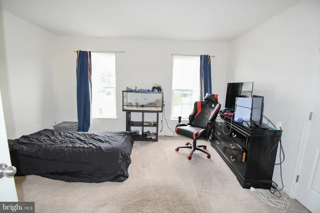a bedroom with a bed gym equipment and a desk