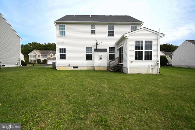a front view of a house with a yard and car parked