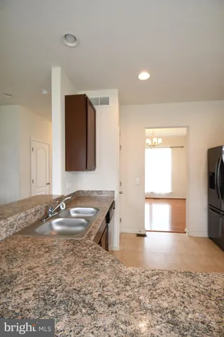 a kitchen with a sink granite counter tops and a window