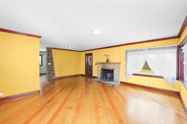 a view of empty room with wooden floor and fireplace