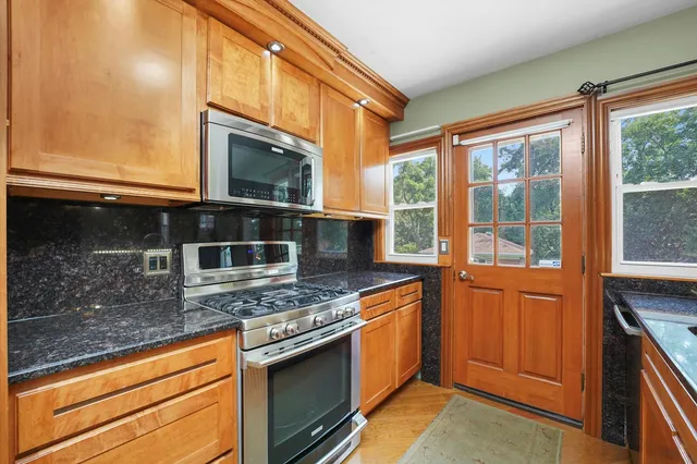 a kitchen with stainless steel appliances granite countertop a stove and a microwave