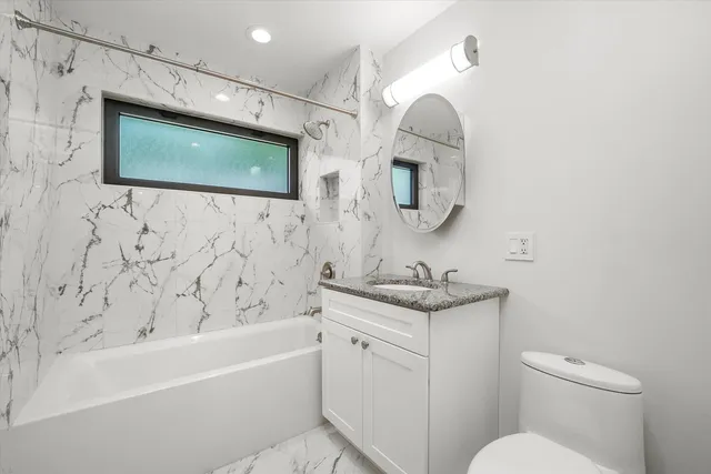 a bathroom with a toilet sink and mirror