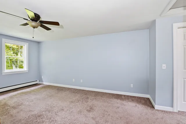 an empty room with a window and a fan