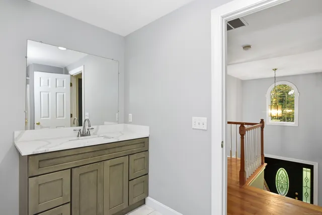 a bathroom with a granite countertop sink and a mirror