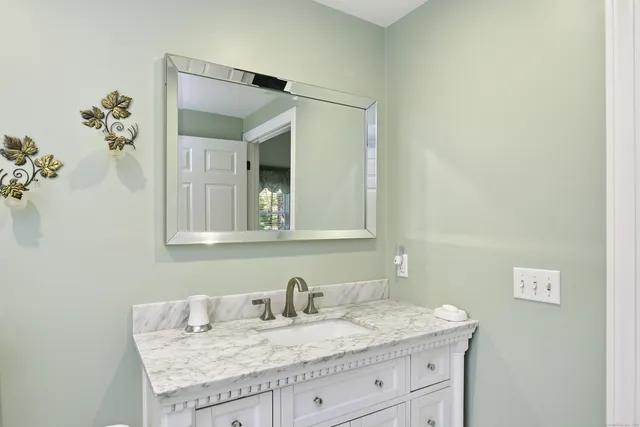 a bathroom with a granite countertop sink and a mirror