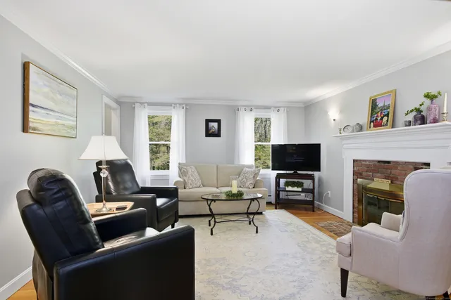 a living room with furniture a fireplace and a flat screen tv