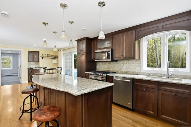 a kitchen with granite countertop a sink cabinets and wooden floor