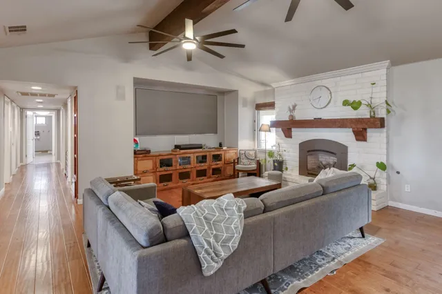 a living room with furniture and a view of kitchen