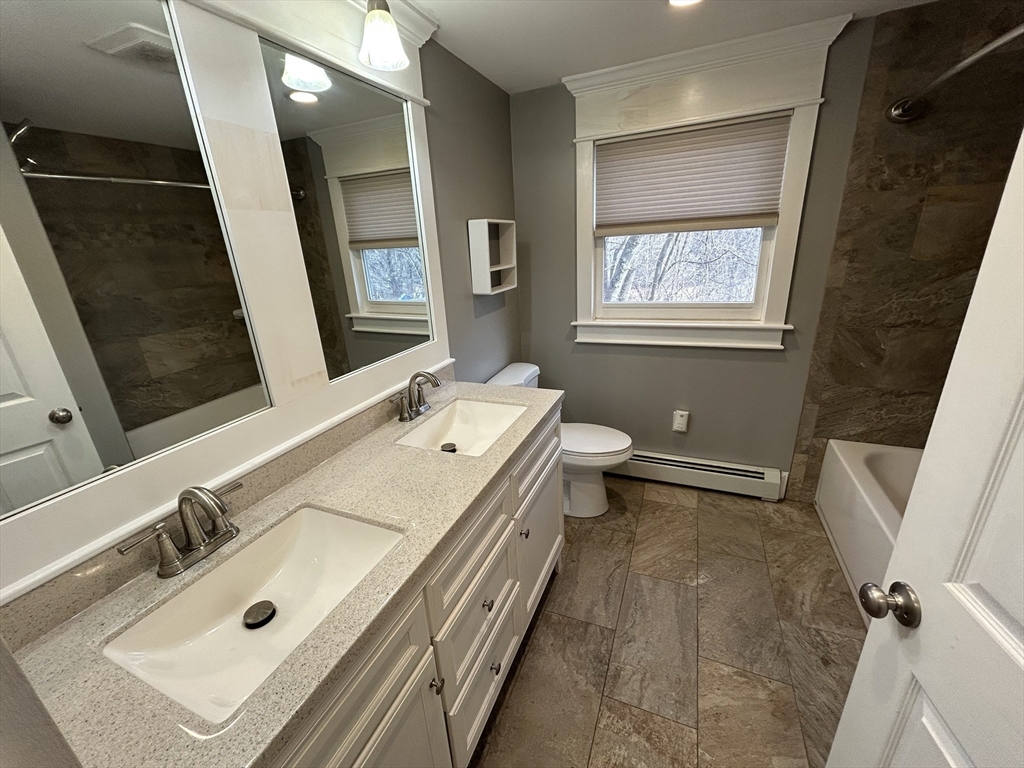 256 Old Webster Road, Unit 1 Oxford, MA 01540 - Photo 14 of 19 a bathroom with a sink mirror and a bath tub