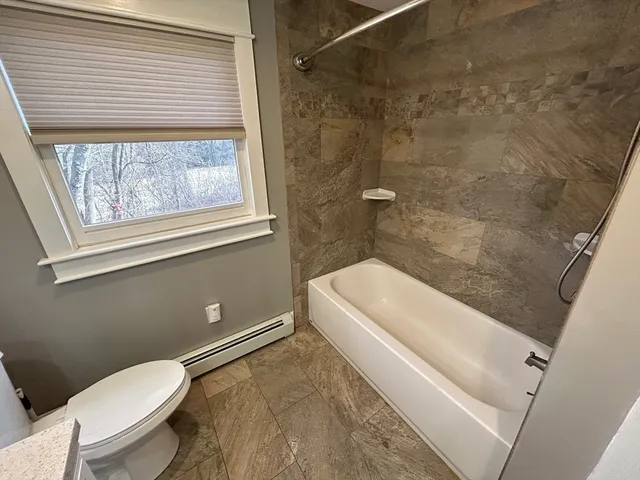a bathroom with a toilet and a shower