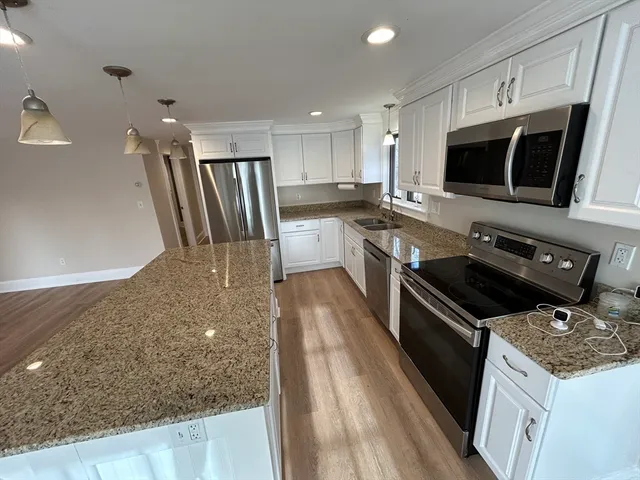 a kitchen with stainless steel appliances granite countertop a stove a sink and a microwave