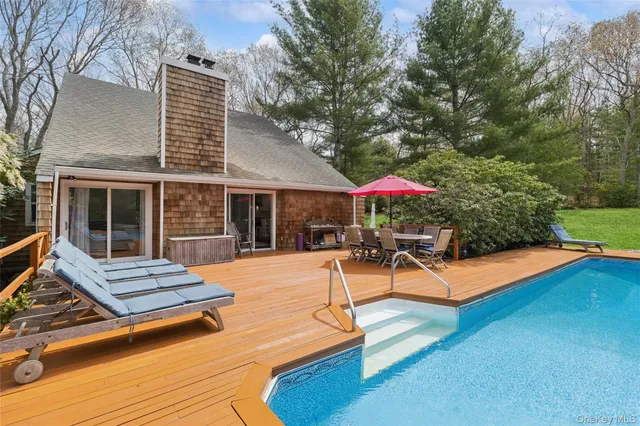 a view of a patio with table and chairs with wooden floor and fence