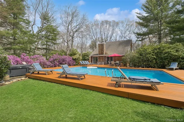 a view of a backyard with table and chairs potted plants and tree