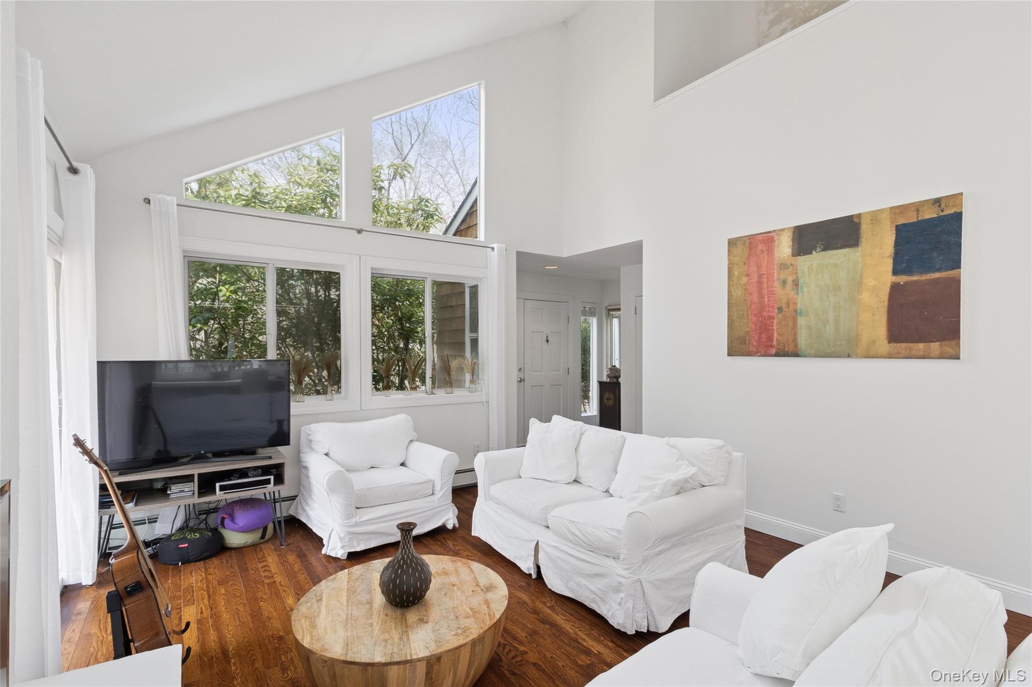27 Ely Brook Road East Hampton, NY 11937 - Photo 4 of 50 Living area featuring high vaulted ceiling, baseboard heating, wood finished floors, and baseboards
