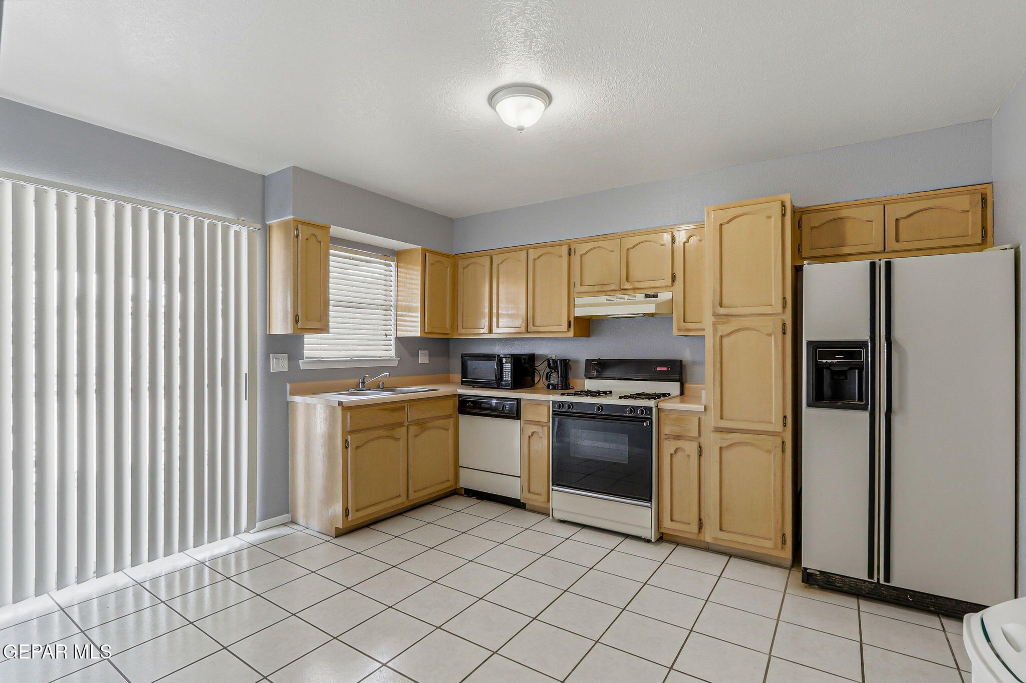 1767 Painted Quail Place El Paso, TX 79936 - Photo 5 of 13 a kitchen with a sink cabinets and stainless steel appliances