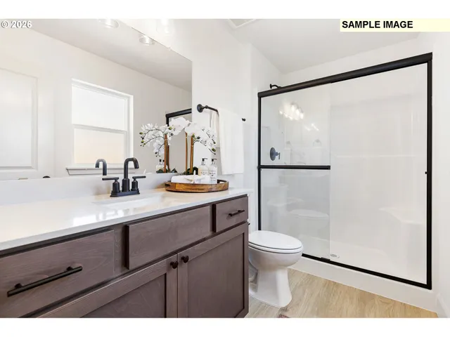 a bathroom with a sink a mirror a toilet and shower