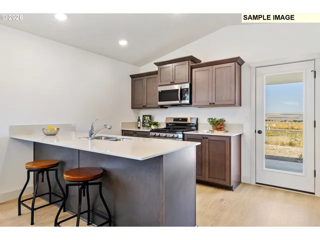 a kitchen with stainless steel appliances a sink and a refrigerator
