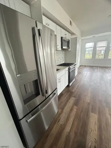 a kitchen with stainless steel appliances a refrigerator sink and microwave