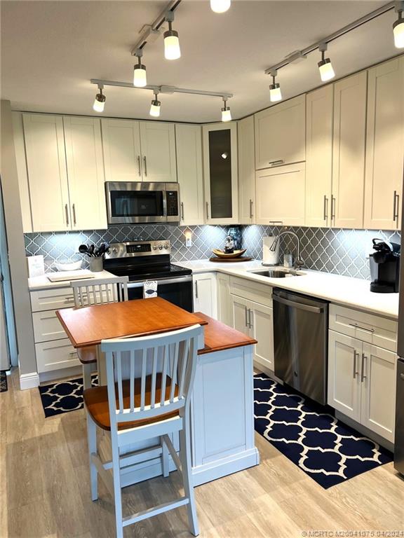 a kitchen with stainless steel appliances a stove a sink dishwasher a stove and a refrigerator