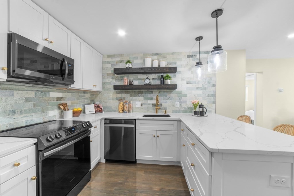 a kitchen with stainless steel appliances a sink dishwasher a stove and a microwave