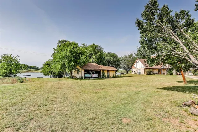 a front view of a house with a yard and trees
