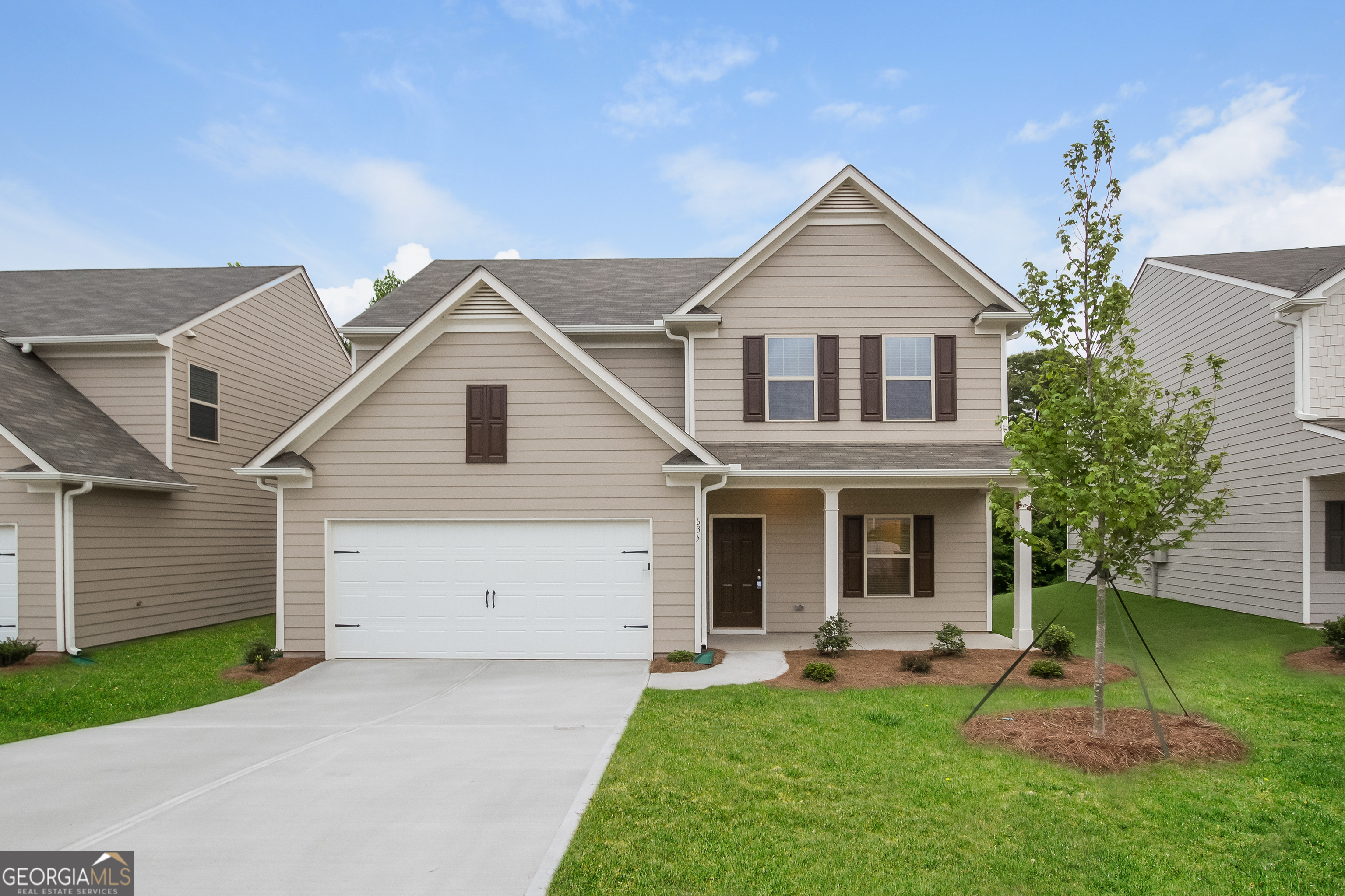 a front view of a house with a yard and garage