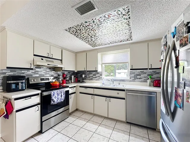 a kitchen with granite countertop a sink stainless steel appliances and cabinets