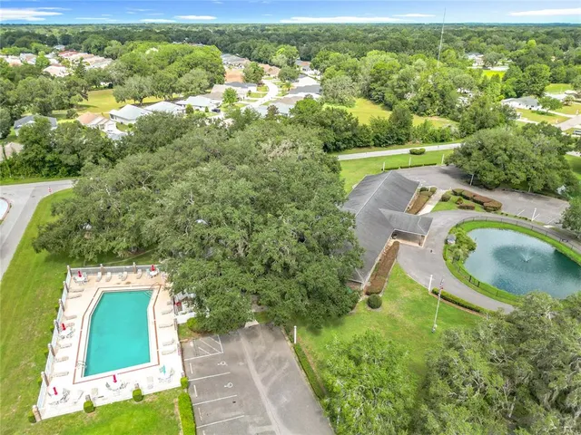 a front view of a house with a garden and lake view