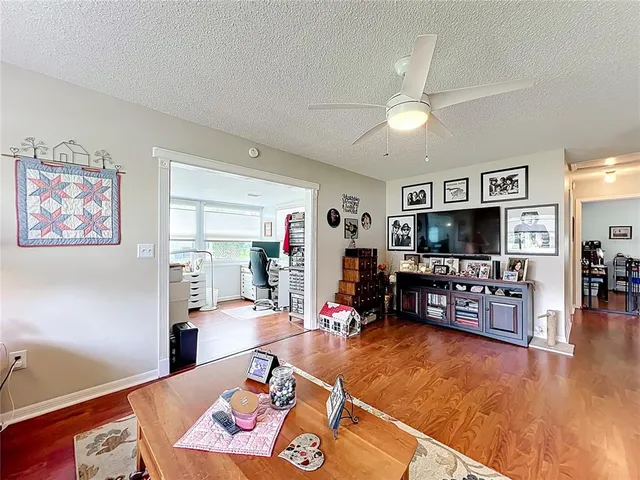 a living room with furniture and a flat screen tv with kitchen view