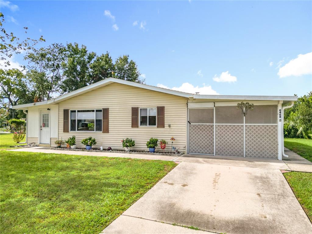 6468 Southwest 107th Place Ocala, FL 34476 - Photo 8 of 53 a front view of a house with a garden and yard