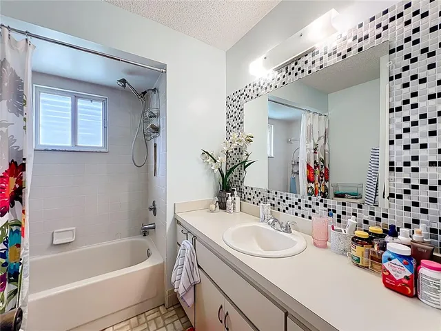 a bathroom with a tub sink and mirror