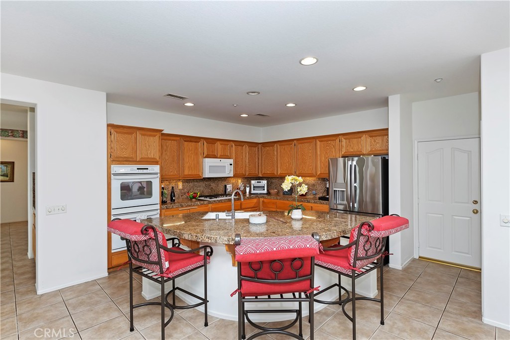11416 Bridgeway Drive Riverside, CA 92505 - Photo 16 of 54 a dining room with furniture and a kitchen view