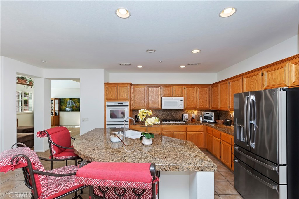 11416 Bridgeway Drive Riverside, CA 92505 - Photo 17 of 54 a kitchen with stainless steel appliances granite countertop a stove refrigerator and dining table