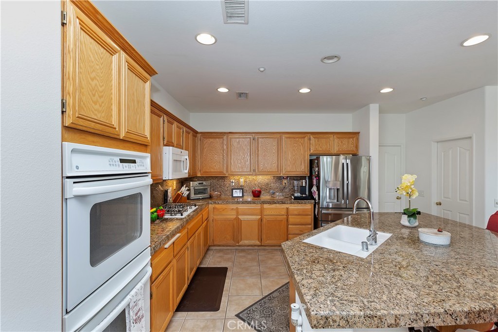 11416 Bridgeway Drive Riverside, CA 92505 - Photo 18 of 54 a kitchen with stainless steel appliances granite countertop a sink stove and refrigerator