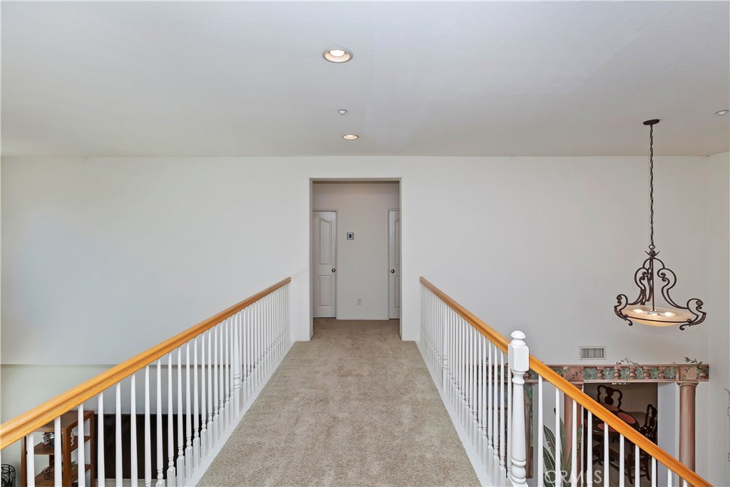 11416 Bridgeway Drive Riverside, CA 92505 - Photo 28 of 54 a view of a hallway with wooden floor and stairs