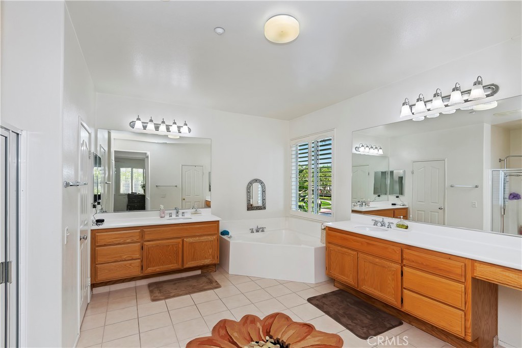 11416 Bridgeway Drive Riverside, CA 92505 - Photo 39 of 54 a spacious bathroom with a double vanity sink a mirror a bathtub and a window