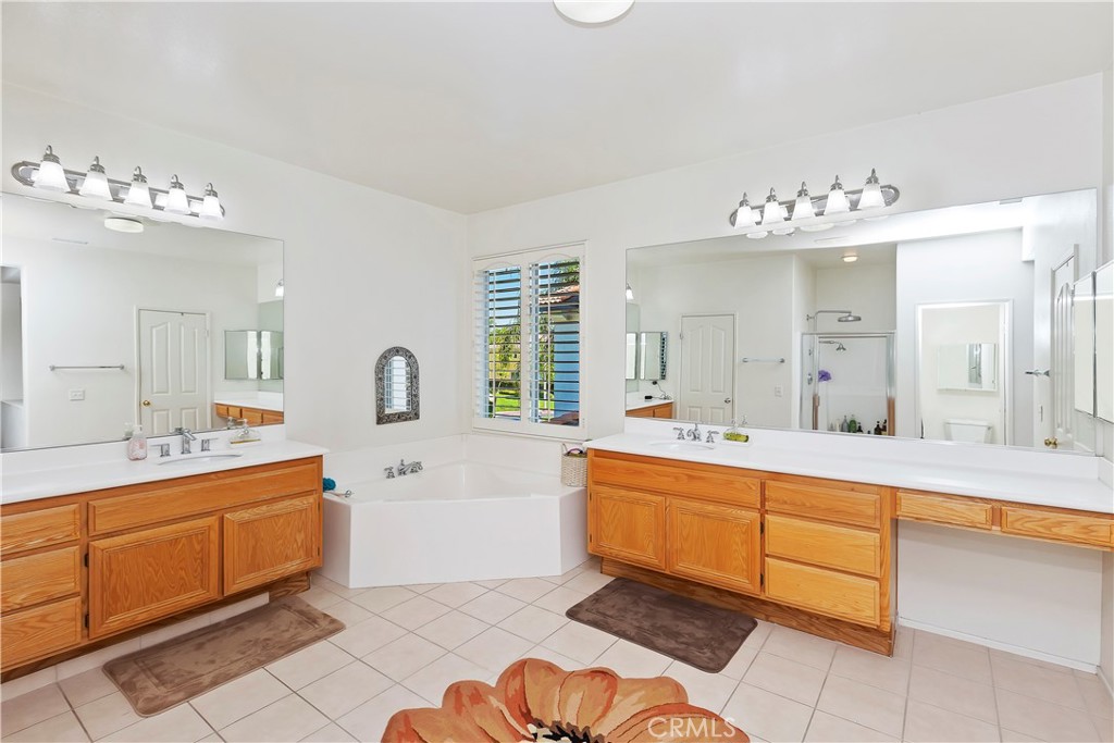 11416 Bridgeway Drive Riverside, CA 92505 - Photo 41 of 54 a large white bathroom with a sink mirror and a bathtub