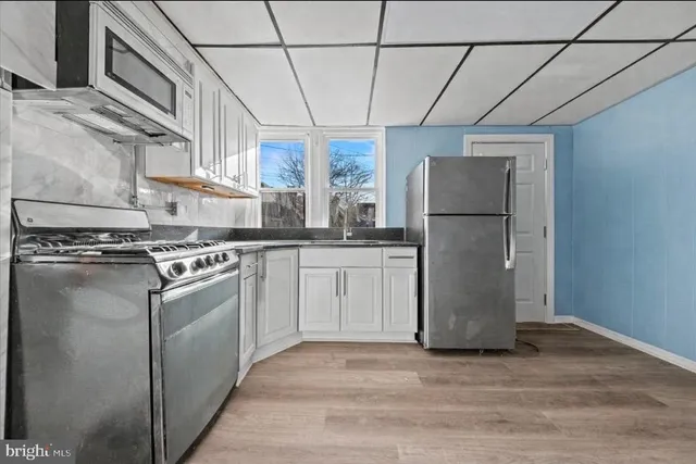 a kitchen with a refrigerator sink stove and cabinets