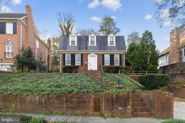 a front view of a house with a yard and potted plants