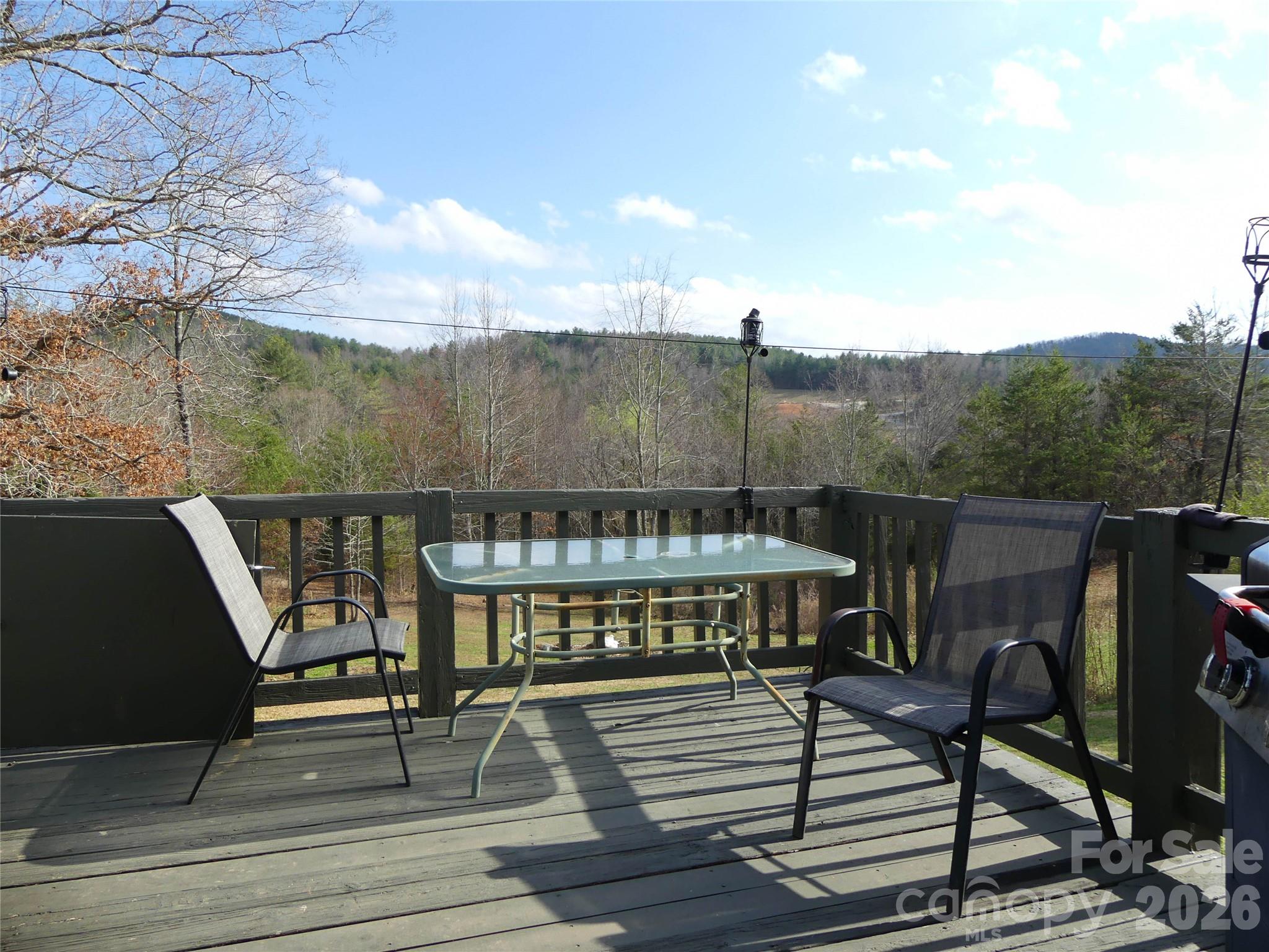 4636 Oak Hill School Road Lenoir, NC 28645 - Photo 2 of 23 a view of a roof deck with table and chairs a barbeque with potted plants