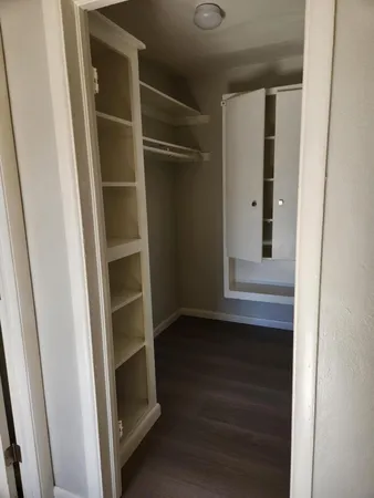 a view of walk in closet with empty racks