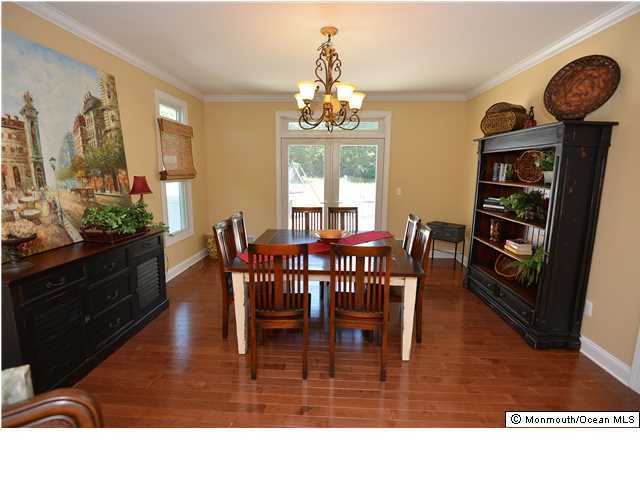 2103 Red Gate Road Allenwood, NJ 08720 - Photo 8 of 25 a view of dining room and livingroom with furniture wooden floor a rug a painting and a chandelier