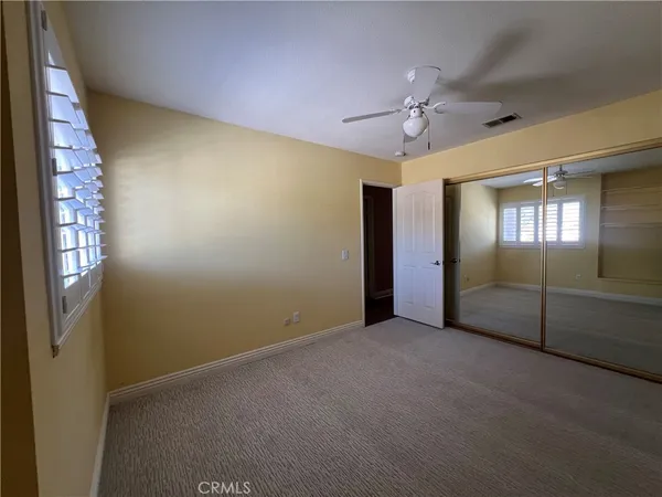 an empty room with fan and windows