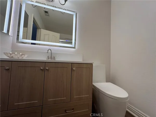 a bathroom with a toilet a sink and mirror