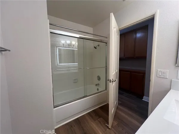 a bathroom with a glass shower door and a sink