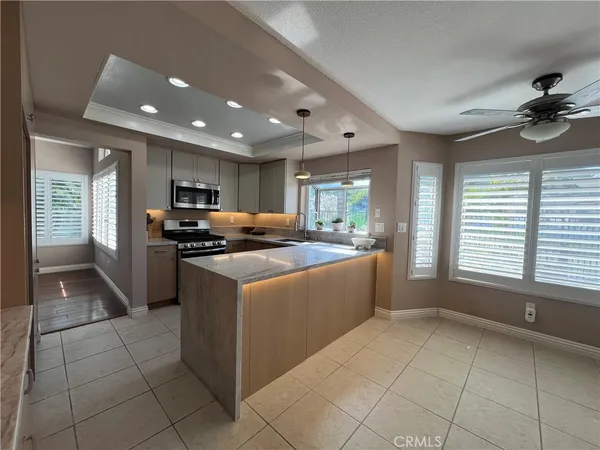 a kitchen with stainless steel appliances granite countertop a refrigerator a sink a stove top oven and a refrigerator