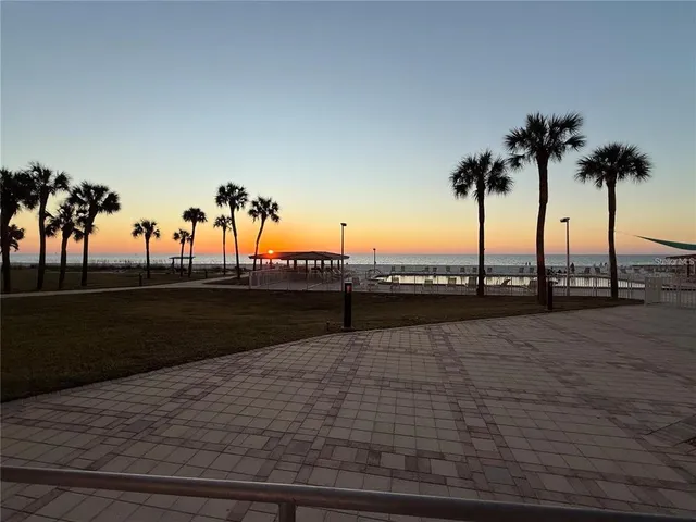 a view of a dining room with furniture water view and tree in front of it